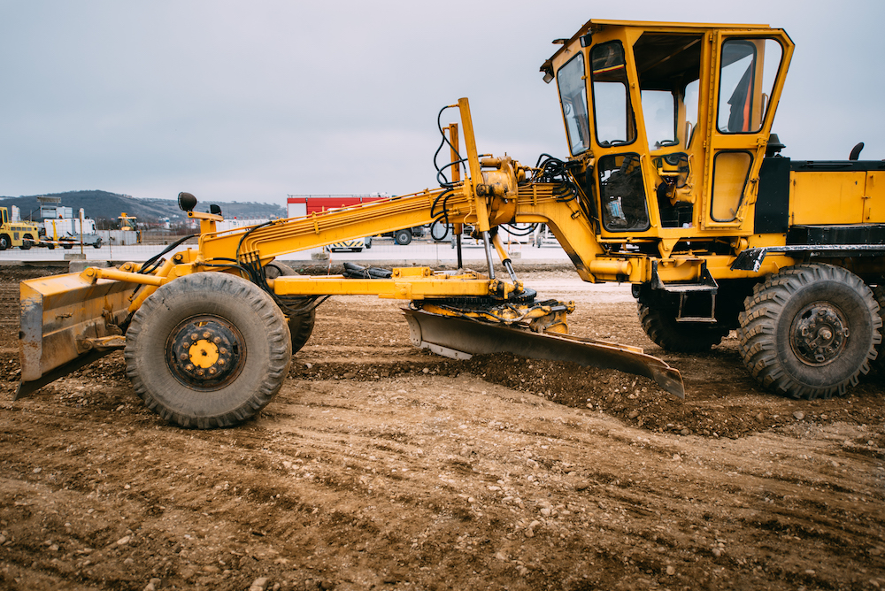 yellow tractor is sitting in a dirt field