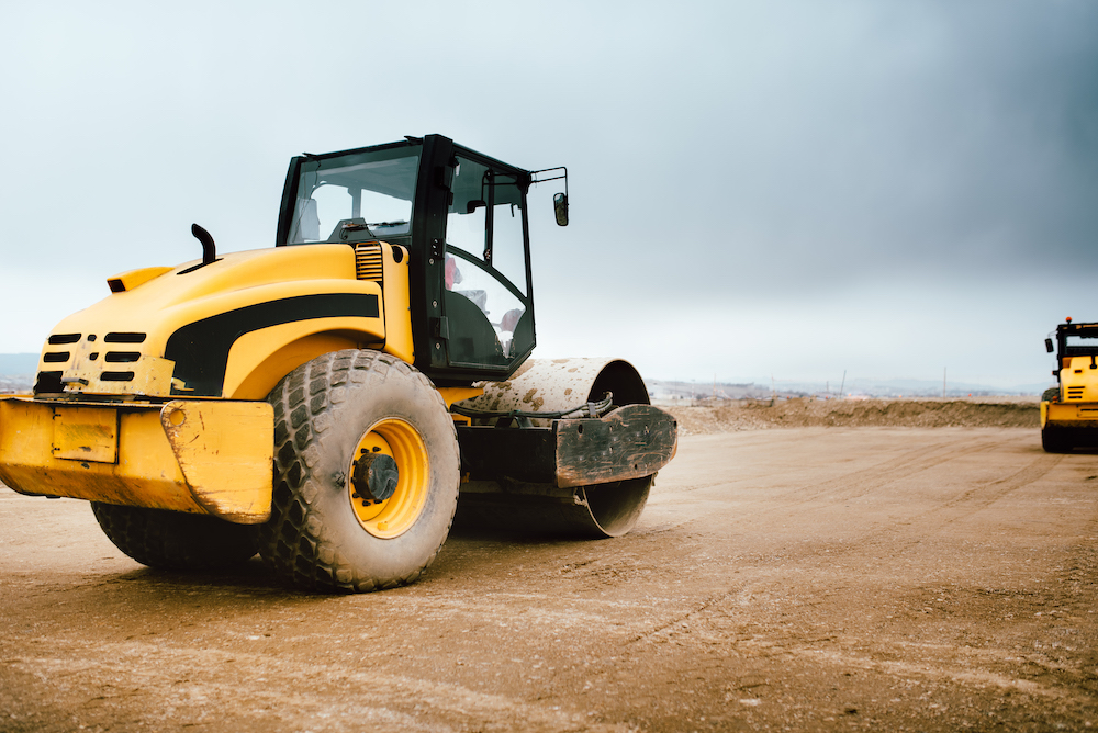 yellow tractor is parked on a dirt road